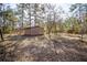 Backyard featuring a storage shed, mature trees, and a partially shaded area at 12175 Phoenix Ave, Weeki Wachee, FL 34614