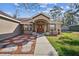 Charming home featuring a covered front entry with decorative pillars and a lovely walkway at 12175 Phoenix Ave, Weeki Wachee, FL 34614