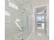 Luxurious walk-in shower with marble tile, a built-in seat, and modern fixtures at 6354 Cocoa Ln, Apollo Beach, FL 33572