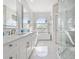 Bright bathroom boasts double vanity, soaking tub under arched windows, and frameless glass shower at 6354 Cocoa Ln, Apollo Beach, FL 33572