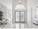 Bright foyer with soaring ceilings, marble floors, modern lighting, and decorative glass front door at 6354 Cocoa Ln, Apollo Beach, FL 33572