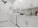 Well-organized laundry room featuring white cabinetry and modern appliances at 6354 Cocoa Ln, Apollo Beach, FL 33572