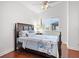 Cozy bedroom with patterned bedding, dark wood furniture, ceiling fan, and natural light at 818 Golf Island Dr, Apollo Beach, FL 33572