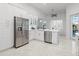 Bright kitchen featuring white cabinetry, stainless steel appliances, and marble floors at 818 Golf Island Dr, Apollo Beach, FL 33572