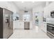 Bright kitchen featuring white cabinetry, stainless steel appliances, and marble floors at 818 Golf Island Dr, Apollo Beach, FL 33572