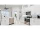 Bright kitchen featuring white cabinets, stainless steel appliances, and a white tile backsplash at 818 Golf Island Dr, Apollo Beach, FL 33572