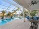 This screened-in pool features comfortable patio seating and ceiling fan overlooking the waterfront at 818 Golf Island Dr, Apollo Beach, FL 33572