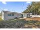 A view of the backyard, showing the exterior of the home and the fence at 8549 Oakhurst Rd, Seminole, FL 33776