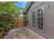 Side view of back entrance with double glass doors, wooden fence and tropical plants at 289 Whisper Lake Rd, Palm Harbor, FL 34683