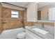 Bathroom featuring a tub, shower with gold tiling, and a sleek vanity with a speckled countertop at 289 Whisper Lake Rd, Palm Harbor, FL 34683