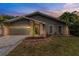 Inviting home exterior showcasing a well-manicured lawn, brick accents, and a two-car garage at 289 Whisper Lake Rd, Palm Harbor, FL 34683