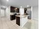 Modern kitchen features stainless steel appliances, a large island with granite countertops, and dark cabinetry at 2764 Emory Sound Pl, Brandon, FL 33510