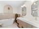 Elegant bathroom with soaking tub, double vanity, and modern fixtures at 3225 Bluff Blvd, Holiday, FL 34691