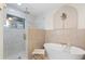 Modern bathroom featuring a soaking tub, glass-enclosed shower, and tile accents at 3225 Bluff Blvd, Holiday, FL 34691