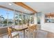 Sunroom dining area with large windows, a wood table and seating for six with outdoor views at 3225 Bluff Blvd, Holiday, FL 34691