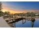 Waterfront property featuring private dock with boat lift amidst a colorful sunset at 3225 Bluff Blvd, Holiday, FL 34691