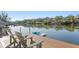 Scenic view of the calm river from the wooden deck with two chairs and a blue kayak at 3225 Bluff Blvd, Holiday, FL 34691