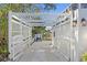 Charming white pergola entrance to the driveway, enhancing the curb appeal of the property at 3225 Bluff Blvd, Holiday, FL 34691