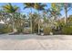 A house featuring a gravel driveway surrounded by lush greenery and palm trees at 3225 Bluff Blvd, Holiday, FL 34691