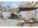 Enclosed pool area with a rock waterfall feature, lush plants, an umbrella, and lounge chairs for relaxation at 3225 Bluff Blvd, Holiday, FL 34691