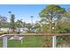 Backyard featuring green grass, trees, and a waterfront view of the neighborhood at 3225 Bluff Blvd, Holiday, FL 34691