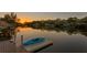 A tranquil waterfront view at sunset featuring a kayak on a floating dock at 3225 Bluff Blvd, Holiday, FL 34691