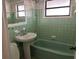 This bathroom features green fixtures, including bathtub and tiled walls at 3923 W Bay View Ave, Tampa, FL 33611