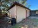 Exterior view of the building with wooden wall panels and a black trash can at 3923 W Bay View Ave, Tampa, FL 33611