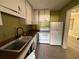 An efficient kitchen featuring white cabinetry, matching appliances, and tile flooring at 3923 W Bay View Ave, Tampa, FL 33611