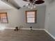 Spacious living room with wood-look floors, a ceiling fan, and multiple windows with wood-toned blinds at 3923 W Bay View Ave, Tampa, FL 33611