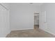 Neutral bedroom showcasing a carpeted floor, closet, and a door to another room at 7327 Brightwaters Ct, New Port Richey, FL 34652