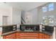 Open kitchen featuring an electric cooktop, granite countertops, dark cabinets and a view of the entry and staircase at 7327 Brightwaters Ct, New Port Richey, FL 34652