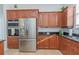 Kitchen with stainless steel refrigerator, granite counters, tile flooring, and dark wood cabinetry at 7327 Brightwaters Ct, New Port Richey, FL 34652