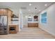 A living room features a stainless steel refrigerator, floating shelves, and wood floors at 357 Rallus Rd, Venice, FL 34293