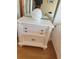 Bedroom nightstand with drawers and a lamp with a white globe, next to a made bed at 1813 Mariner Dr # 152, Tarpon Springs, FL 34689