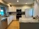Bright kitchen featuring white cabinetry, stone countertops, stainless appliances, and a center island at 1813 Mariner Dr # 152, Tarpon Springs, FL 34689