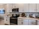 Modern kitchen featuring stainless steel appliances, white cabinetry, and stylish backsplash at 23819 Collina Way # 011101, Port Charlotte, FL 33980