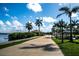 A walking path lined with palm trees leads to community amenities and waterfront views at 23819 Collina Way # 011101, Port Charlotte, FL 33980