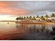 Scenic waterfront view featuring a picturesque sunset and palm trees at 23819 Collina Way # 011101, Port Charlotte, FL 33980