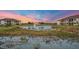 Water view of new construction community with a beautiful pond and colorful sky at sunset at 23819 Collina Way # 11201, Port Charlotte, FL 33980