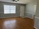 Living room features wood flooring, a large window, neutral paint, and a ceiling fan at 12350 Mitchell Ter, Port Charlotte, FL 33981