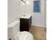Bathroom featuring a white sink vanity, mirror, and toilet complemented by neutral tile flooring at 4508 Golfwood Blvd, Tampa, FL 33634