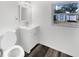 Bathroom featuring a white vanity, toilet and a window overlooking the backyard at 4508 Golfwood Blvd, Tampa, FL 33634