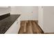 Kitchen featuring granite countertops, white cabinets and hardwood floors at 4508 Golfwood Blvd, Tampa, FL 33634