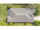 Birds-eye view of roof and lush surroundings; lovely landscaping with trees and palms, and a well-kept lawn at 11530 57Th Street E Cir, Parrish, FL 34219