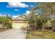 Charming single-story home featuring a two-car garage and a well-manicured front yard with mature trees at 11530 57Th Street E Cir, Parrish, FL 34219