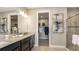 Bathroom featuring double vanity, stone countertops, a framed mirror, and a glass-enclosed shower with tile surround at 29549 Zupetta Ln, Wesley Chapel, FL 33545