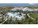 Aerial view of a luxurious community pool area with lounge chairs, umbrellas, and lush landscaping at 29549 Zupetta Ln, Wesley Chapel, FL 33545