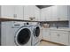 Clean laundry room with white cabinetry, modern washer and dryer, and a utility sink for convenience at 29930 Radice Ct, Wesley Chapel, FL 33545