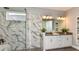 Luxurious bathroom featuring a glass-enclosed shower and double vanity with marble countertops at 4488 Isonzo Way, Wesley Chapel, FL 33543